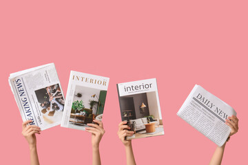 Female hands with different magazines and newspapers on pink background