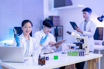 Obraz premium Woman scientist researcher raising hand holding magnify glass as working with colleagues in lab room