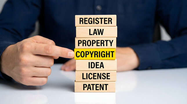 Professional hand pointing at copyright block in a stack of legal words on a desk