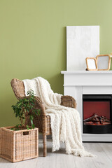 Naklejka premium Interior of stylish living room with armchair, painting and blank frames on fireplace