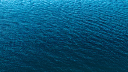Top view of deep blue sea water surface with small ripples, aerial drone shot of turquoise ocean texture at island , abstract nature background 