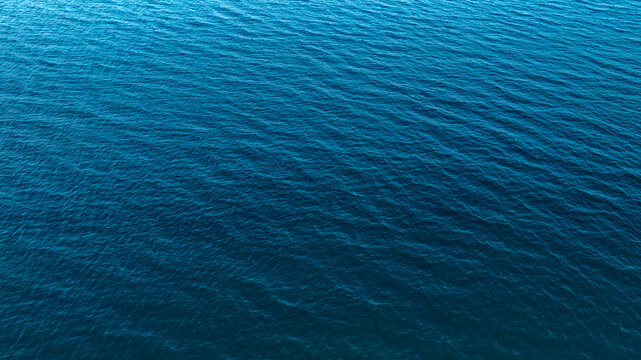 Top view of deep blue sea water surface with small ripples, aerial drone shot of turquoise ocean texture at island , abstract nature background 