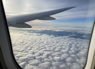Obraz premium Aerial view of fluffy white clouds from an airplane window