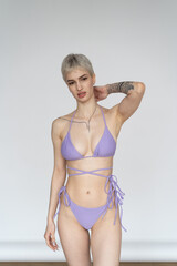 Fototapeta premium young beautiful woman poses in pink lingerie in a studio