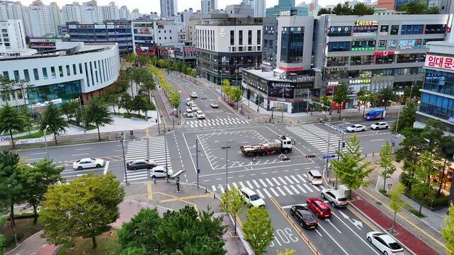 Drone footage of modern urban intersection and city traffic in Daegu during autumn