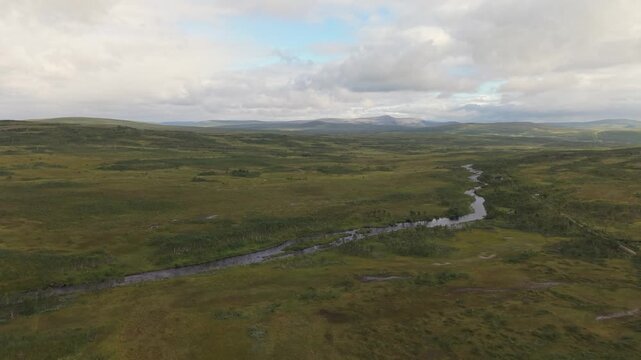 A Winding River Flows Through Open Tundra Beside the E69 Road in Finnmark, Norway - Drone Flying Forward