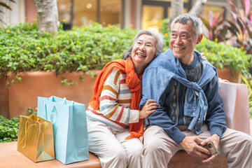Naklejka premium Happy senior asian couple love and laughing together outdoors, elderly husband and wife enjoying retirement lifestyle and travel in winter, active aging, insurance and health care concept