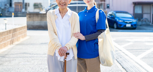 高齢女性と介護・買い物代行スタッフの同行シーン／地域支援・生活サポート訴求