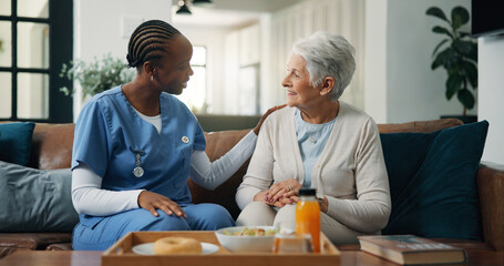 Conversation, nurse and senior woman on sofa in home for healthcare consultation with diagnosis. Discussion, checkup and caregiver with elderly female person for medical treatment plan in living room © WesJVR/peopleimages.com
