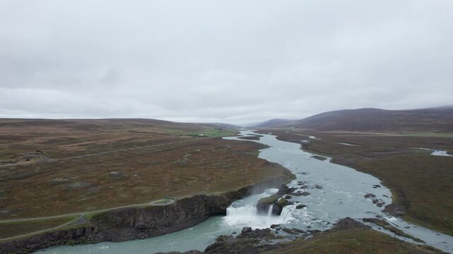 Aerial drone shot flying over Godafoss Waterfall, massive waterfall in northern Iceland