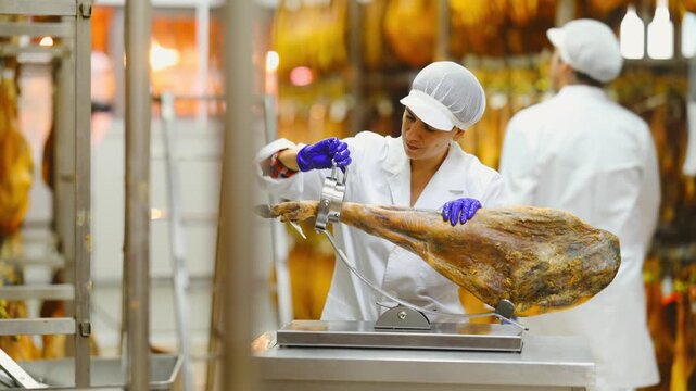 Female worker places ham on a jamonero to cut it into appetizing pieces. Ham factory. High quality 4k footage