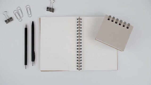 Top View of Minimal Workspace with Open Notebook and Stationery, Right to Left Camera Motion Flat Lay for Productivity and Office Concept