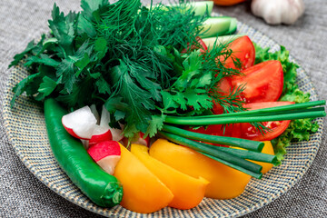 Close-up of fresh sliced red tomatoes, dill, and green onions on a wooden surface