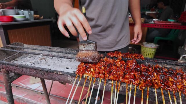 close-up of satay chicken grilled over charcoal