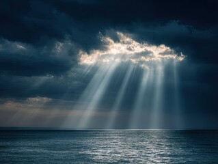 Fototapeta premium Dramatic sunbeams pierce dark clouds over a vast, calm ocean surface