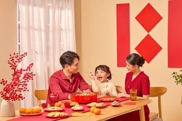 An Asian family gathers around a holiday table, creating a peaceful scene of celebration within a...
