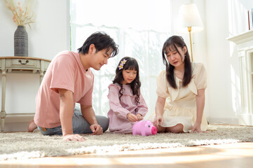 Fototapeta premium Family Spends Time Together Teaching Kids About Saving Money With a Piggy Bank in a Bright Room