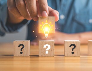 Hand places lightbulb block above question marks, symbolizing ideas