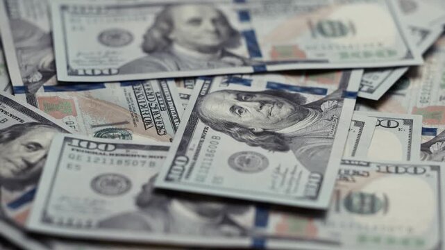 Close-up view of scattered US dollar banknotes showing detailed designs and textures, emphasizing the progression of wealth and financial abundance across the frames