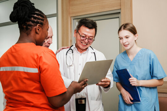 A diverse team of healthcare professionals collaborates on a medical report in a clinical environment. The scene highlights teamwork, trust, and shared expertise in patient care and health improvement