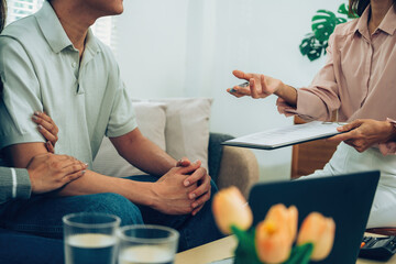 Couple Discussing Health Insurance Policy with Female Agent at Home