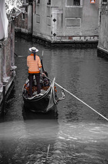 Obraz premium Italy, Venice, September 29, 2025, A gondolier in a red and white striped shirt is transporting tourists in Venice