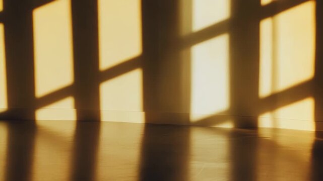 Golden hour light casting dramatic geometric shadows from a window frame onto a minimalist interior wall and wooden floor, creating an abstract and serene atmosphere