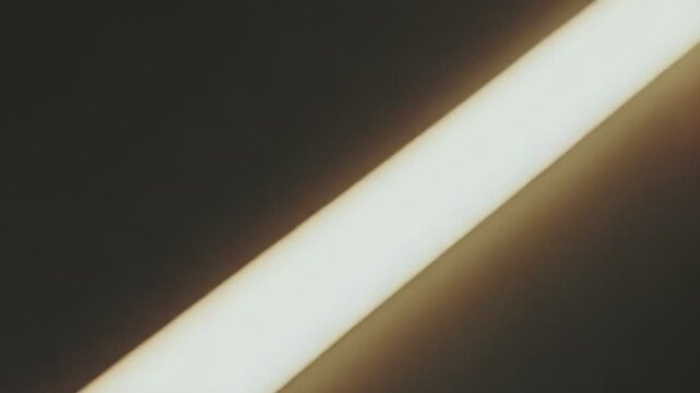 Abstract parallel light strip diagonally dividing a dark, shadowy space, creating a visual metaphor for progress, clarity, minimalism, technology, and energy