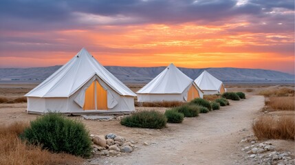 Glamping bell tents at sunset in desert landscape
