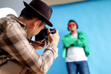 Photographer Capturing Model in Studio with Blue Background