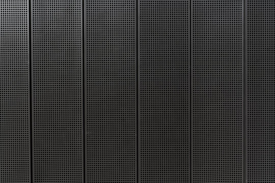 Dark perforated metal wall texture with geometric industrial pattern