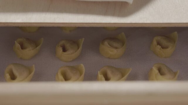 Uncooked tortellini pasta in wooden box