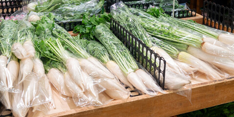 直売所に並ぶ袋詰めされた大根のクローズアップ