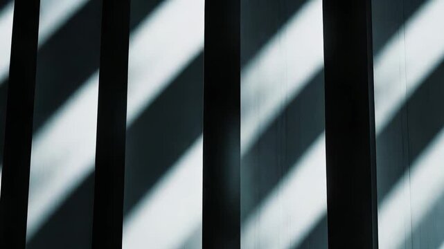 Abstract composition showcasing strong contrasting light and shadow patterns on a textured wall, creating a minimalist and geometric backdrop with sharp lines and dark spaces