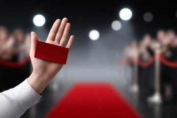 Here response following all given guidelines red carpet arrival, hand holding ticket with