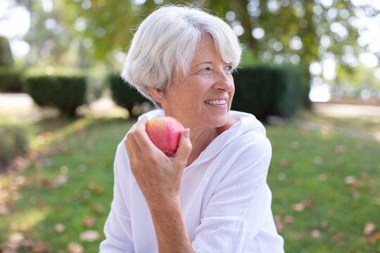mature smiling woman with apple