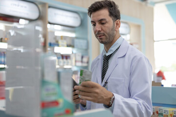 Pharmacist examining medication packaging with focus and precision. Male healthcare professional...
