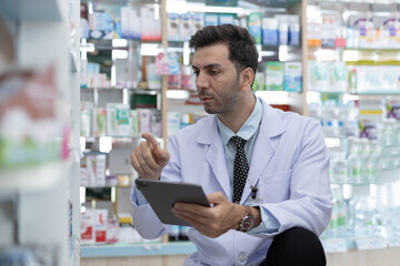Pharmacist using digital tablet to identify and organize medications. Male healthcare expert...