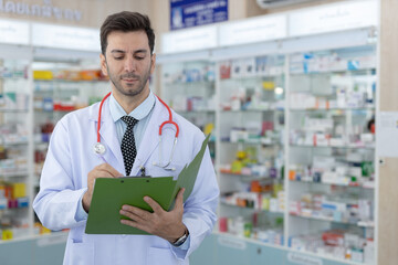 Male pharmacist or doctor writing medical notes on clipboard with focus professionalism. Using...