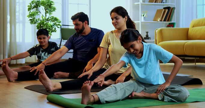 Indian family doing yog asana at home practicing janu shirasana seated head to knee yoga together indoors during calm morning hours inside a modern lavish living space promoting healthy lifestyle