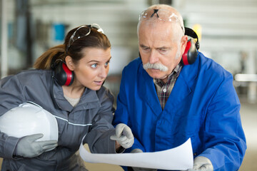 female manual worker asking question to supervisor holding paperwork