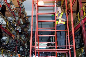 Warehouse worker meticulously examining the storage racks