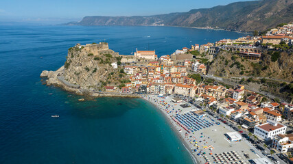 Fototapeta premium Aerial view of the historic center of the town of Scilla, in Calabria, Italy. Panorama of a beautiful village located on a promontory overlooking the Mediterranean Sea. In foreground it's the beach.