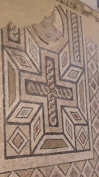 Vertical panning footage showing stunning geometrical mosaic with greek inscription. Ancient mosaic shows symmetrical geometric cross motif of interlocking lines. Villa of The Birds, Alexandria, Egypt