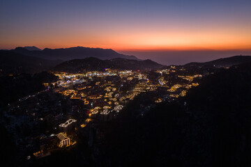 Night view of illuminated buildings nestled in Lushan Mountain, Jiangxi China as dusk settles