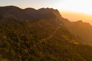 Obraz premium Tourists walk along a scenic mountain path in Lushan Mountain, Jiangxi China during sunset