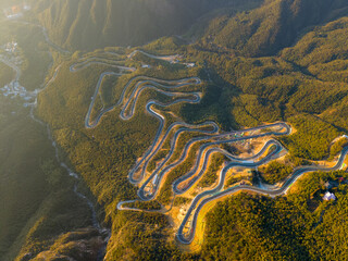 Obraz premium Aerial view of winding road through lush forests on Lushan Mountain in Jiangxi China