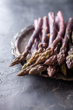 Purple asparagus and gourmet food styling on dark background