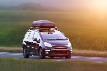 Fototapeta premium Vehicle driving on country road with roof cargo box