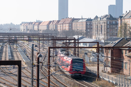 Train and railway tracks cutting through urban cityscape in Copenhagen Denmark showing infrastructure for transport and travel connections
